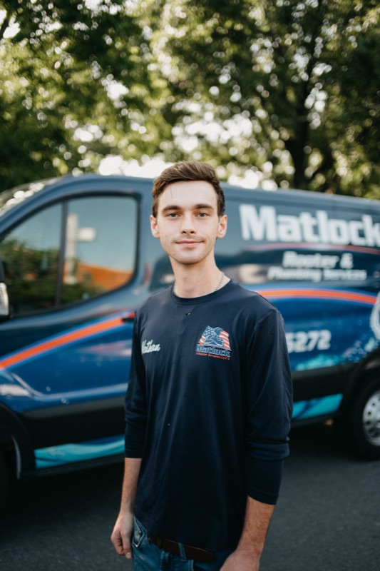 Young Matlock crew member in front of the company van
